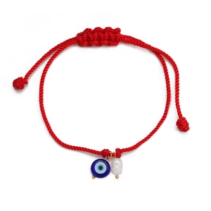 Detail of red braided evil eye bracelet with white pearl and adjustable knot