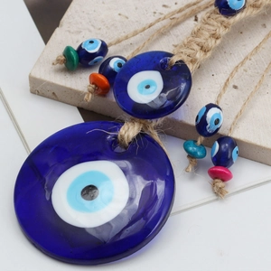 Macro shot of blue glass Nazar evil eye pendant with braided jute rope and colorful beads