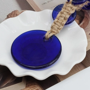 Détail macro du pendentif mauvais œil en verre bleu avec corde de chanvre tressée