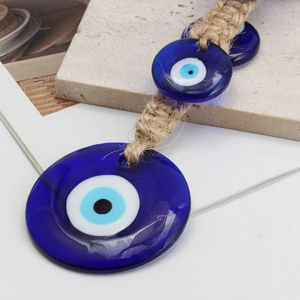 Détail de breloques en verre Evil Eye turc avec décoration en corde de chanvre tressée