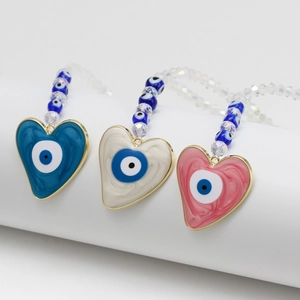 Vue détaillée des pendentifs cœur mauvais œil en bleu, blanc et rose avec perles
