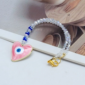 Détail de perles en cristal facetté avec pendentif cœur œil protecteur et fermoir