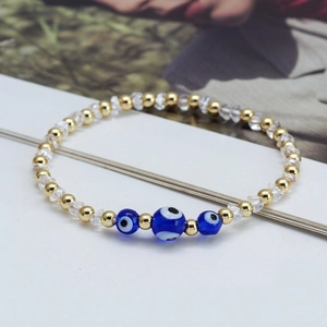Bracelet bohème en perles dorées avec charmes œil bleu et perles en cristal clair