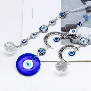Detailed close-up of evil eye moon charms with crystal ball and blue beads on silver chain