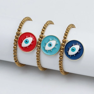 Détail de trois bracelets œil protecteur en rouge, bleu ciel et marine avec perles dorées
