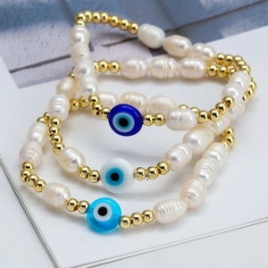 Three-piece Evil Eye pearl bracelet set with golden beads on white display card