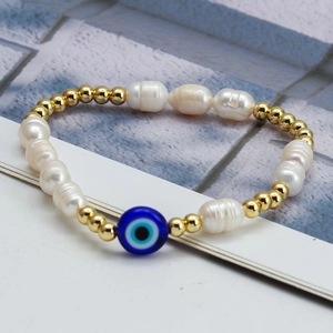 Detail view of baroque pearl bracelet with gold beads and blue evil eye charm