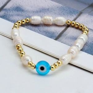 Macro detail of Evil Eye pearl bracelet featuring blue glass beads and gold spacers