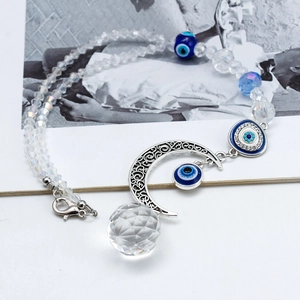 Detail of evil eye beads with crescent moon pendant and faceted crystal ball keychain