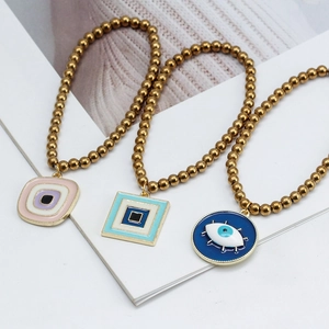 Trois colliers de perles dorées avec pendentifs colorés mauvais œil pour femmes élégantes