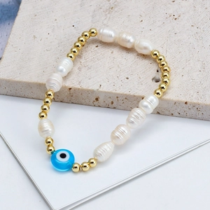 Bohemian pearl bracelet with gold metal beads and a blue evil eye charm for protection