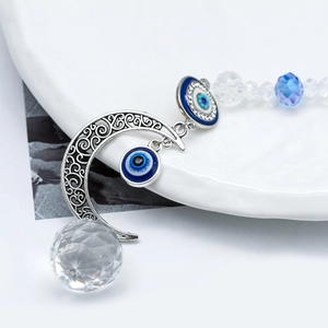 Detail of moon pendant with blue evil eye beads and multifaceted clear crystal ball