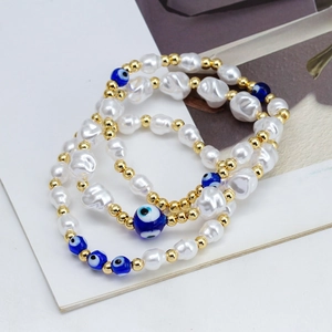 Three-piece set of evil eye beaded bracelets with white pearls and gold metal spacers