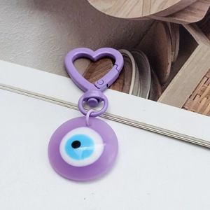 Detail of purple Evil Eye charm with heart-shaped clasp for keychains and bag decoration
