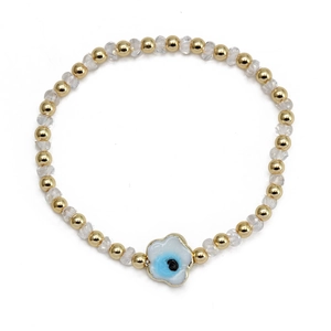 Gros plan détaillé du bracelet en perles dorées avec un pendentif œil bleu protecteur