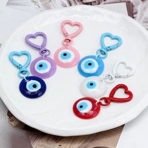 Detail of colorful Evil Eye heart keychains in blue, pink, and white on a tray