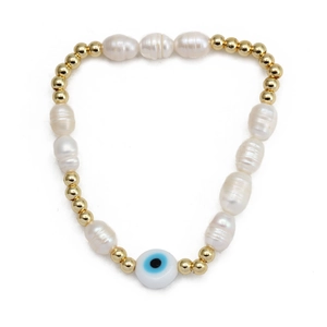 Macro view of evil eye bead and natural pearl bracelet with golden metal accents