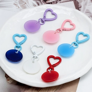 Colorful heart-shaped clasps and round acrylic evil eye keychains in vibrant hues