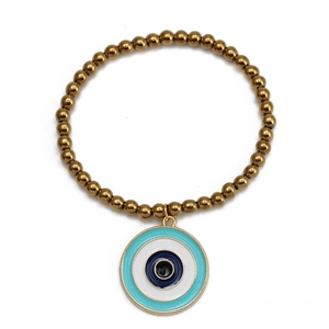 Détail d'un bracelet en perles dorées avec un pendentif œil porte-bonheur en émail bleu
