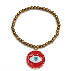 Détail macro du bracelet à billes dorées avec pendentif protecteur Evil Eye rouge