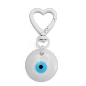 Detail view of a white heart-shaped clasp with a blue evil eye lucky charm pendant