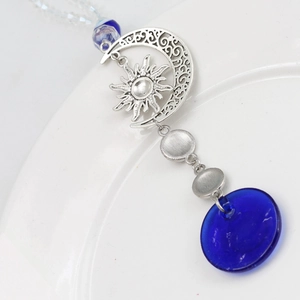 Evil eye keychain with sun and moon alloy charms and a large blue glass pendant