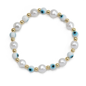 Detail of beaded evil eye bracelet with white faux pearls and golden spacers on white backdrop