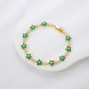 Vista macro del bracciale floreale dorato con petali di zircone verde e chiusura a scatto