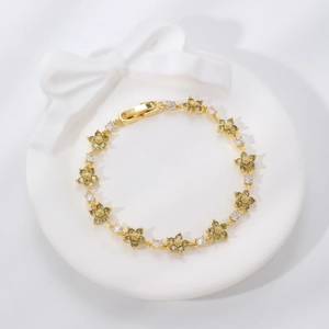 Lussuoso bracciale floreale dorato con zirconi verdi su vassoio bianco a rilievo