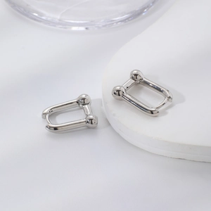 Minimalist silver U-shaped horseshoe earrings with polished mirror finish and ball ends