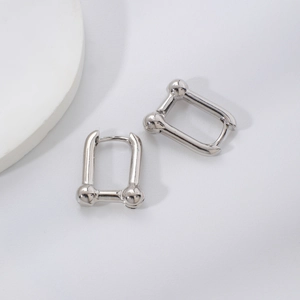 Macro view of polished silver U-shape link earrings with modern sphere detailing