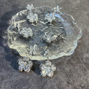 Elegant long plum blossom silver earrings with sparkling cubic zirconia on glass plate