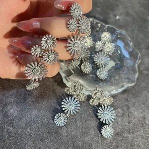 Macro detail of long silver floral earrings with sparkling cubic zirconia flower design