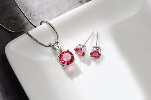 Detailansicht der rosa Zirkonia-Halskette und Ohrringe auf einem Keramiktablett