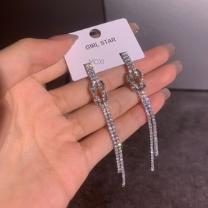 Long silver tassel knot earrings with sparkling rhinestones for an elegant party look