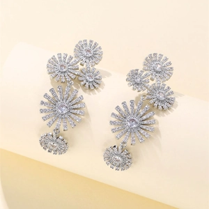 Macro shot of long daisy earrings with cubic zirconia inlay on elegant display