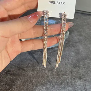 Detailed view of rose gold long tassel earrings with sparkling rectangle cut zircons