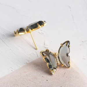 Boucles d'oreilles papillon dorées avec cristal gris fumé et accents scintillants