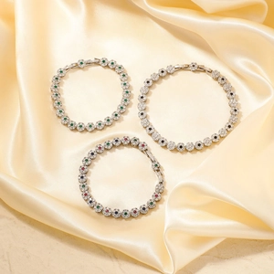 Detalle de pulseras de tenis de flores con circonitas de esmeralda, zafiro y rubí rojo