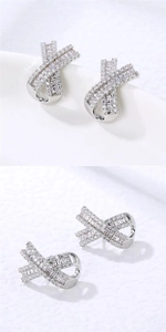 Detailed close-up of geometric X-shaped earrings with sparkling baguette and round crystals