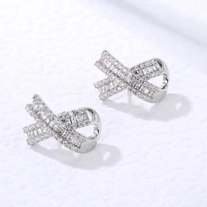 Minimalist geometric crisscross stud earrings with pavé set baguette and round diamonds