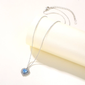 Nahaufnahme des herzförmigen blauen Edelsteinanhängers mit silberner O-Kette und Verschluss