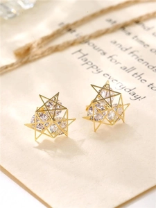 Detailed close-up of hollow geometric star earrings with sparkling zircon crystals