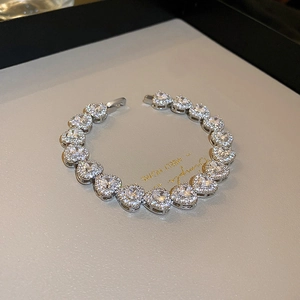 Macro view of silver heart link bracelet with high-clarity pavé-set zircons and secure clasp