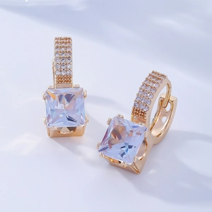 Détail de boucles d'oreilles zircon carré avec pavé de diamants sur créoles en or
