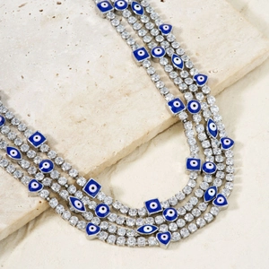 Collar de mal de ojo plateado con circonitas y colgantes de ojos azules de varias formas