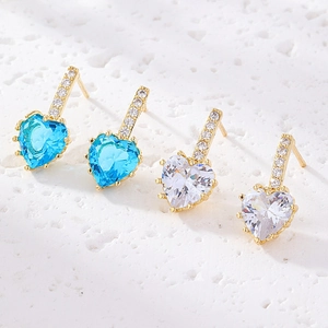 Vue détaillée de boucles d'oreilles cœur en or avec zircons étincelants bleus et blancs