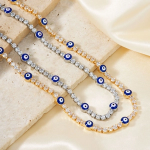 Collares Mal de Ojo en oro y plata con circonitas cúbicas sobre tela de seda color champán