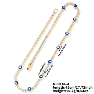 Detalle de cadena de tenis dorada con circonitas blancas y amuletos de ojo azul