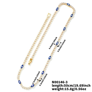 Detalle del collar de cadena dorada con dijes de ojo turco azul y medida de longitud